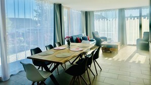 A dining area with a wooden table, black chairs, and a vase of flowers. - Exclusive 5-room maisonette architect's house with panoramic lake view and penthouse roof terrace (Öhningen)