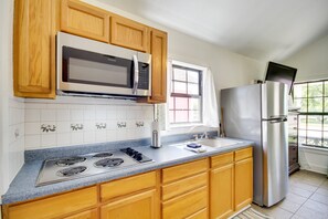 Enjoy cooking in this well-equipped kitchen with a gas stove, microwave, and refrigerator, plus a convenient window with an outdoor view.