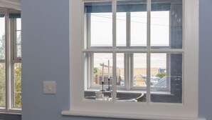 A room with a large window overlooking a beach. - Chic 2-Bed Seafront Haven, Near Felpham Beach (Felpham)