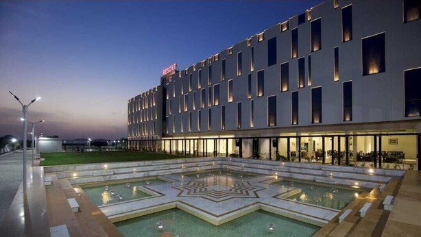 Un hotel moderno con un amplio espacio de piscina que presenta diseños geométricos.