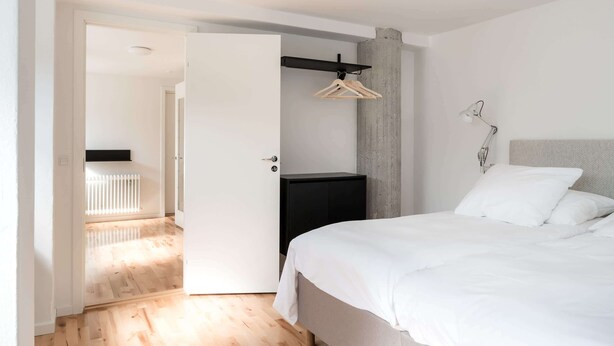 Een moderne slaapkamer met een bed, een kledingkast en een hangrek.