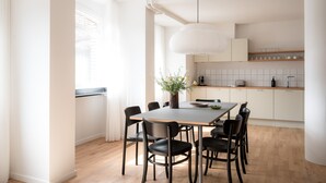Een moderne keuken met witte kastjes, een houten aanrecht en een eethoek met tafel en stoelen.