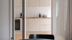 Een moderne keuken met witte kasten, een houten aanrechtblad en een broodrooster.