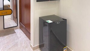 A room with a wooden wardrobe, a mirror, a black cabinet, and a mounted television. - Richmond Down Town  (Cairo)