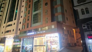 Un hotel de varios pisos con fachada moderna, con amplias ventanas y espacio comercial en la planta baja.