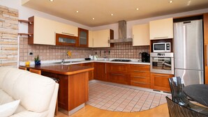 Een moderne keuken met houten kastjes, een roestvrijstalen koelkast en een inbouwoven.