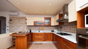 Een moderne keuken met houten kastjes, een centraal eiland en een inbouwoven.