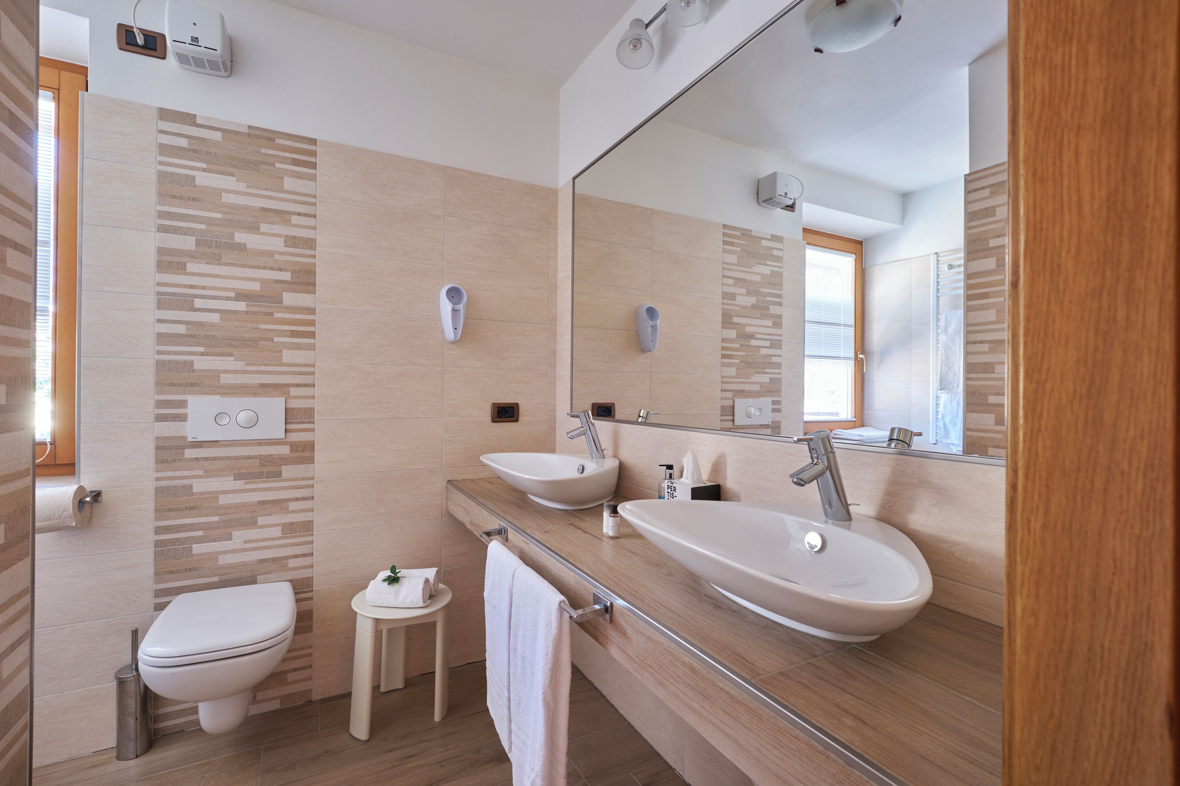 Un baño moderno con inodoro, lavabo, espejo y bidé.