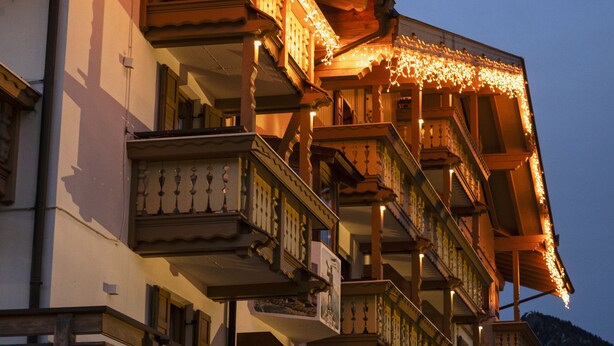Un edificio de varios pisos con balcones decorados con luces de adorno.