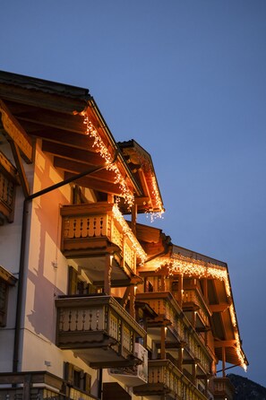 Un edificio de varios pisos con balcones decorados con luces de adorno.