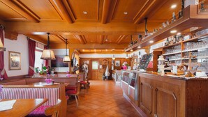 Un restaurante acogedor con interiores de madera, una zona de bar y una sección de mesas.