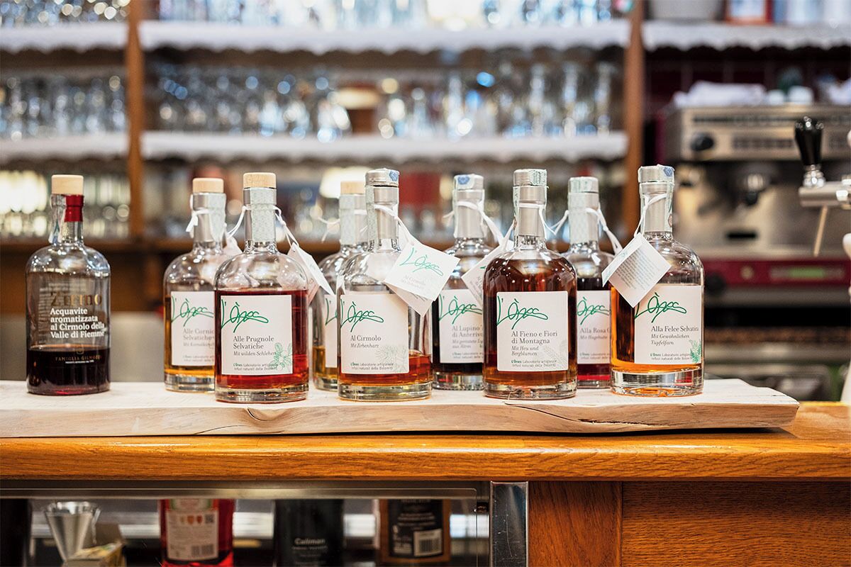 A bar counter with various bottles of liquor, including a distinct bottle of Acquavite.