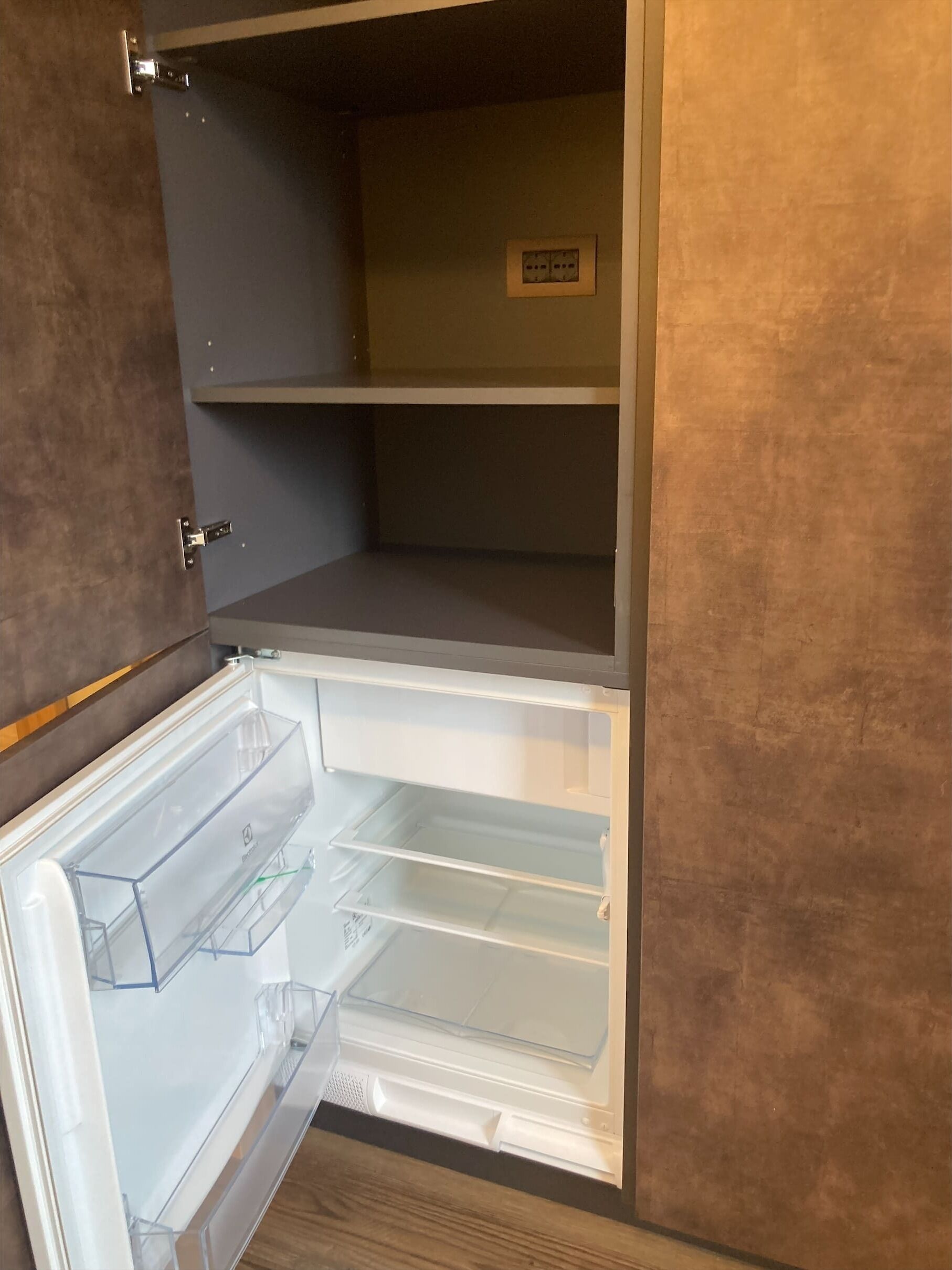 An open refrigerator with transparent shelves and a control panel on the door.