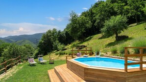 A wooden deck with a hot tub overlooking a lush green landscape and a pool. - Wonderful  villa for 6 people with private pool, WIFI, TV and panoramic view, close to Florence (Gricignano)