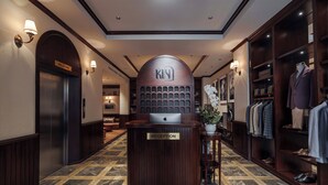 A hotel reception area with a reception desk, a 'Welcome' sign, a 'Reception' sign, and a shoe display. - Kin Hotel Dong Du (Ho Chi Minh City)