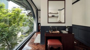 A modern room with a large window, a wooden bench, a dark console table, and a mirror on the wall. - Kin Hotel Dong Du (Ho Chi Minh City)