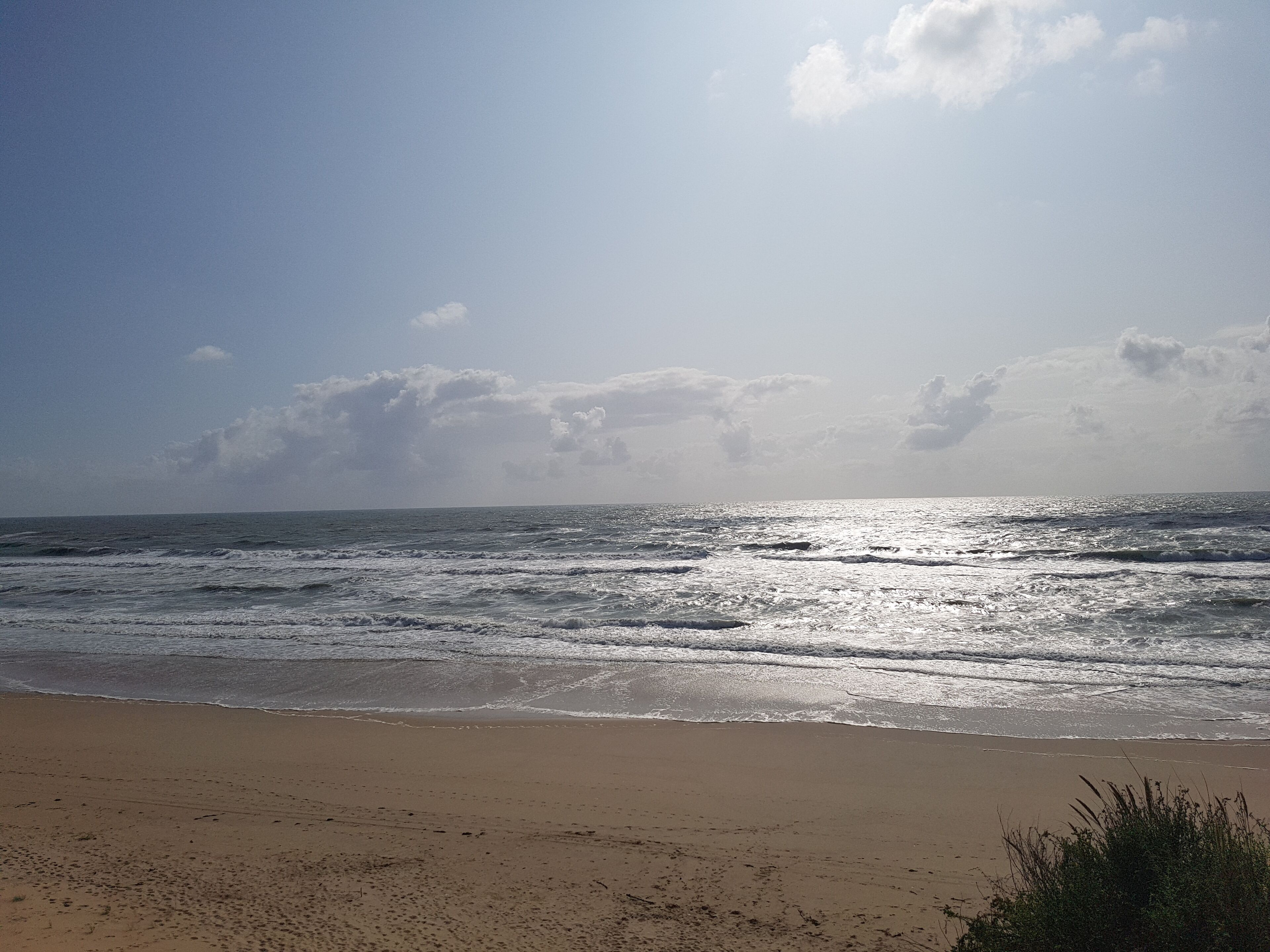 Una playa con olas y cielo despejado.