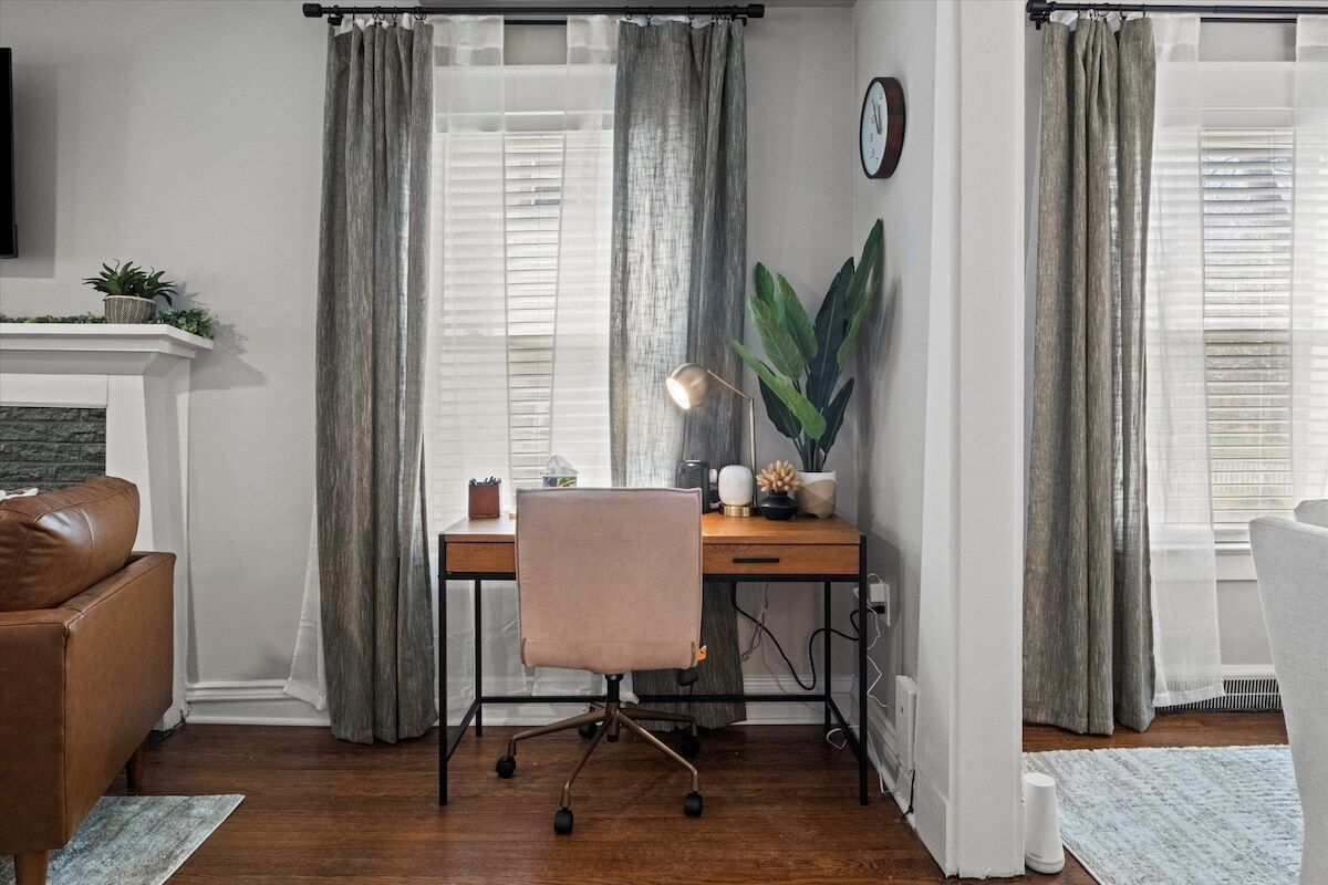 Una habitación con escritorio, silla y chimenea.