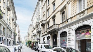 Une rue bordée de bâtiments historiques, de voitures garées et de devantures de magasins fermées.