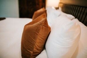 Een bed met witte en bruine kussens.
