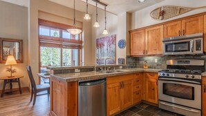 A kitchen with wooden cabinets, stainless steel appliances, and a granite countertop. - Home Near Sierra Golf Course! Just a Short Walk to the Shuttle! (Mammoth Lakes)