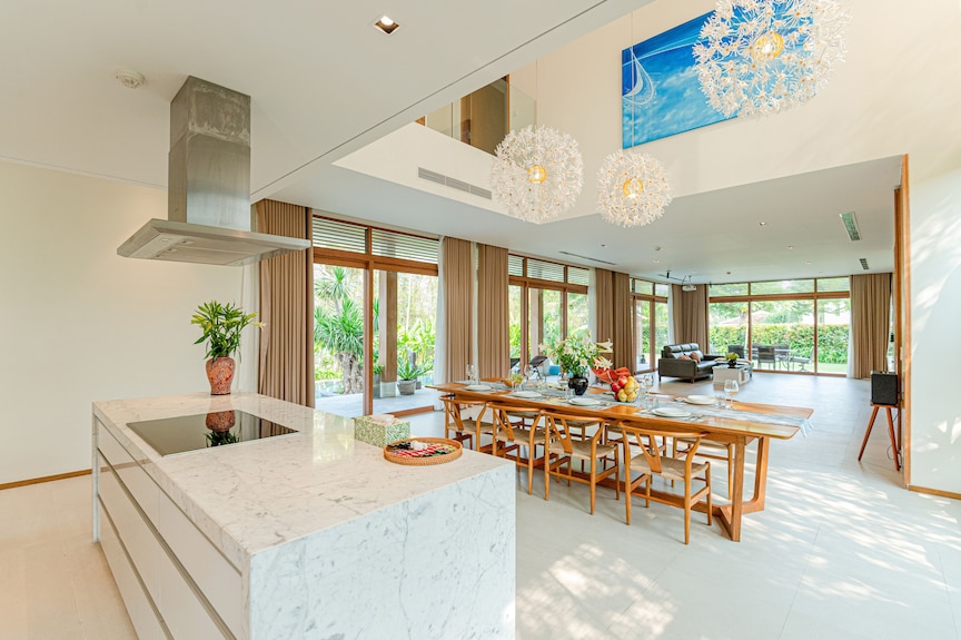 Bếp đảo và bàn ăn lớn hỗ trợ nhóm khách sinh hoạt trong villa nguyên căn