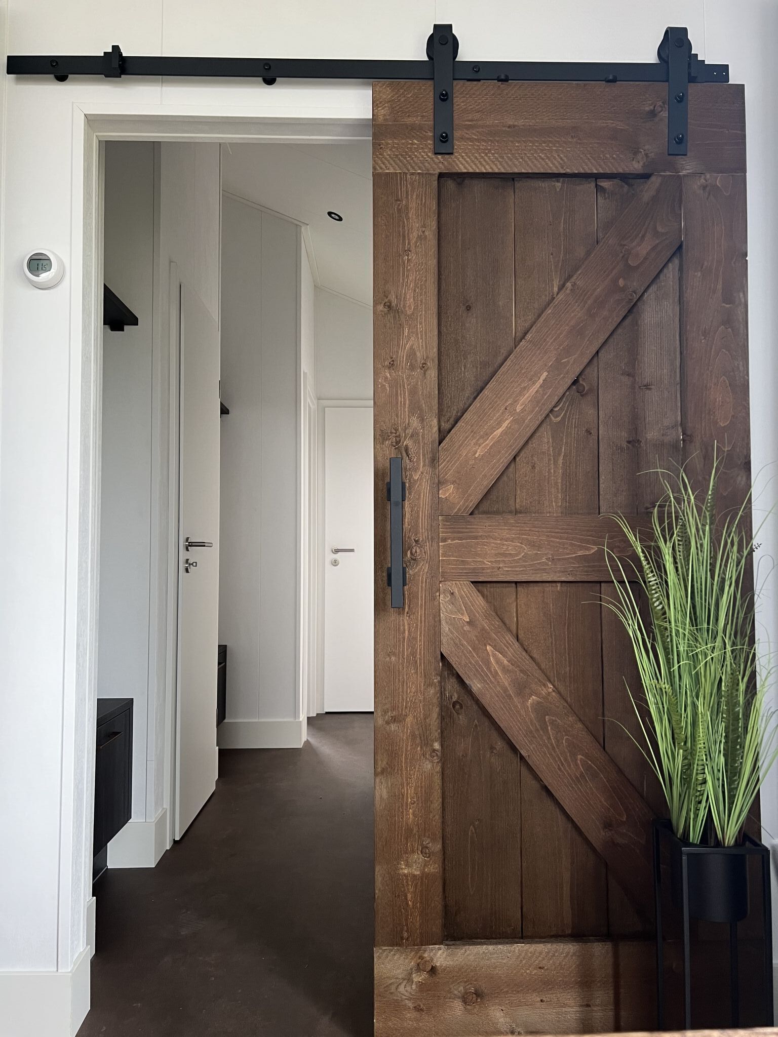 A hallway with a wooden barn-style door and a sliding barn door.