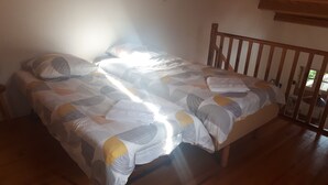 Una cama doble con ropa de cama estampada, un cabecero de madera y suelo de madera.