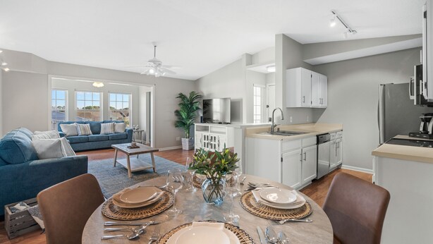 Un appartement moderne comprenant un coin repas, une cuisine et un salon.