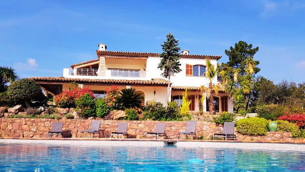 Una casa de dos pisos con piscina delantera.