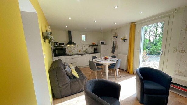 A modern living room with a sofa, two armchairs, a dining table, and a kitchen in the background. - Charming Gîte with Private Garden, Close to Amboise, Perfect for Relaxation and Exploration (Pocé-sur-Cisse)