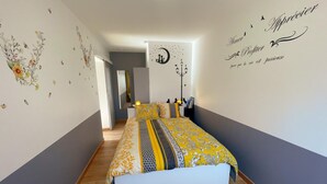 A bedroom with a bed, a mirror, and a wall with decorative elements. - Charming Gîte with Private Garden, Close to Amboise, Perfect for Relaxation and Exploration (Pocé-sur-Cisse)