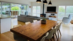 Un espace de vie moderne comprenant un coin repas, un canapé, un téléviseur et une cheminée.