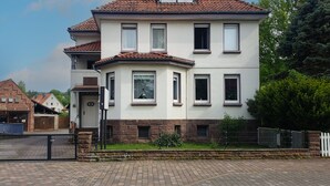 Ein zweistöckiges Gebäude mit einem Ziegeldach, zahlreichen Fenstern und einem Backsteinportal.