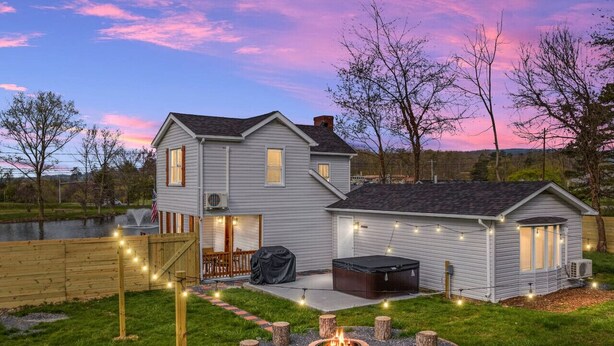A two-story house with a hot tub, deck, and fire pit. - Pondview 4BR Cabin-Walk to Caverns, Hot Tub, Wi-Fi (Luray)