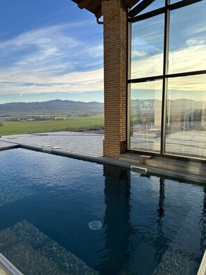 An infinity pool with a clear view of a mountainous landscape through large windows. - La Valle del Re (Medesano)