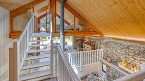 A wooden interior with a stone wall and a fireplace. - Le Chalet des Eaux Piscine (Revel)