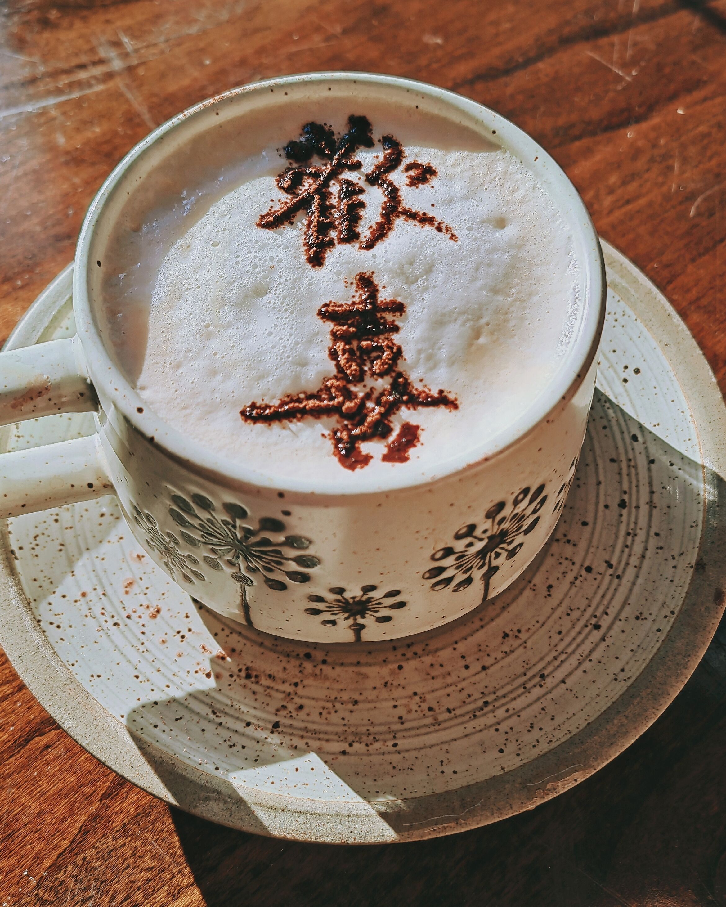 En kop kaffe med latte-kunst på en underkop.