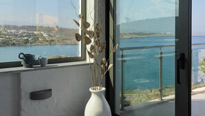 Uma varanda com vista para um corpo de água e um horizonte urbano distante.