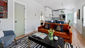 A modern living room with a sofa, coffee table, and a ceiling fan. - Zen Den (Atlanta)