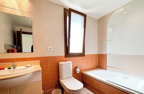 Un baño moderno con lavamanos, inodoro y bañera.