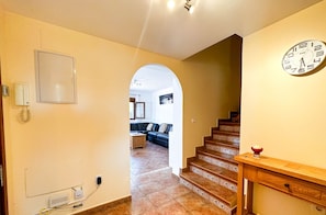 A staircase leading to a living area with a clock on the wall. - Bright 3-Bedroom Townhouse • Las Lomas • BAU01 (Ayamonte)