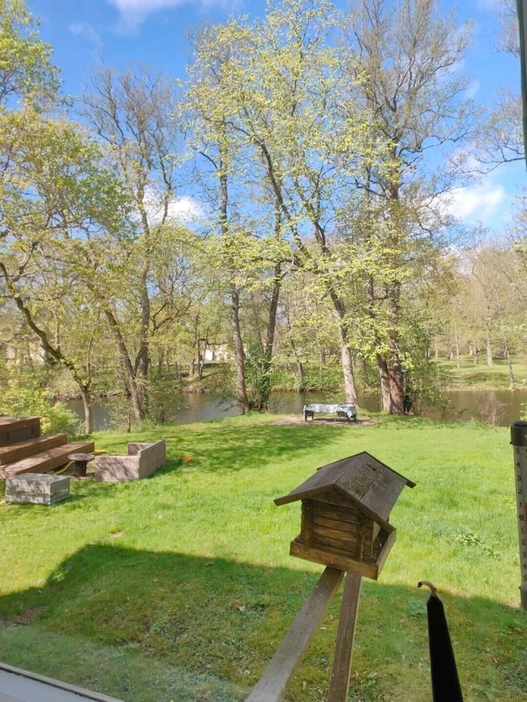 A park with picnic tables and a birdhouse.