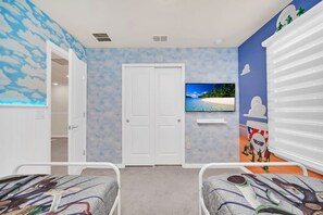 A bedroom with a bed, a TV, a wardrobe, and a door.