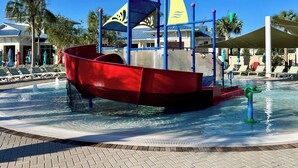 Ein Wasserspielplatz mit einer Piratenschiff-Anlage und einem Pool.