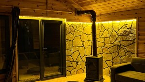 Una stanza accogliente con una parete in pietra, un camino e pavimento in legno.
