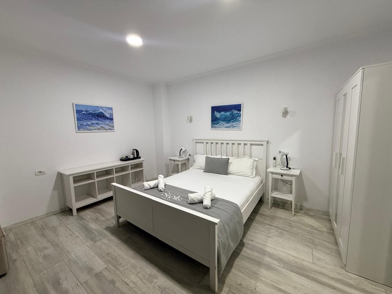 Une chambre à coucher moderne avec un lit, des tables de chevet et une armoire.