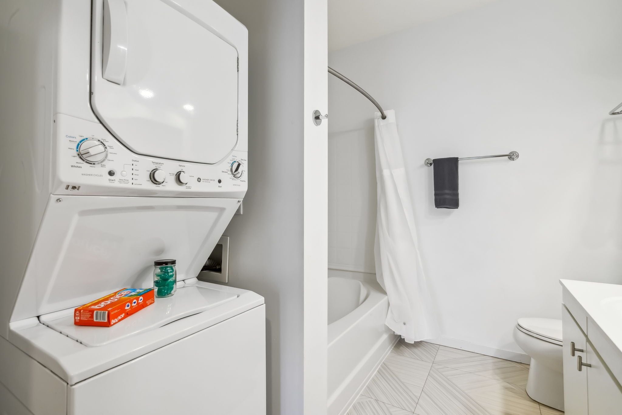 Ein modernes Badezimmer mit einer weißen Waschmaschine, einer Badewanne und einer Toilette.