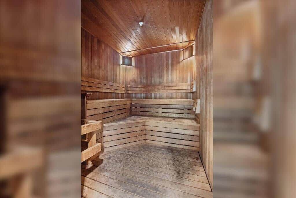 A sauna with wooden benches and a sloped floor, designed for relaxation.