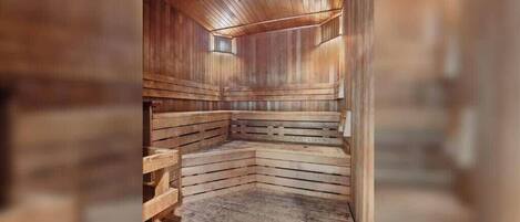 A sauna with wooden benches and a sloped floor, designed for relaxation.